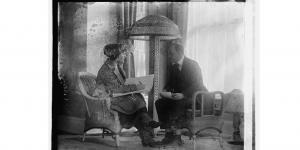 1920 female census enumerator sits next to a man and writes down his responses to the 1920 census