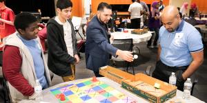 Juan Valentin (center) works with high school students during the U.S. Patent and Trademark Office's  2017 Engineering Week. 
